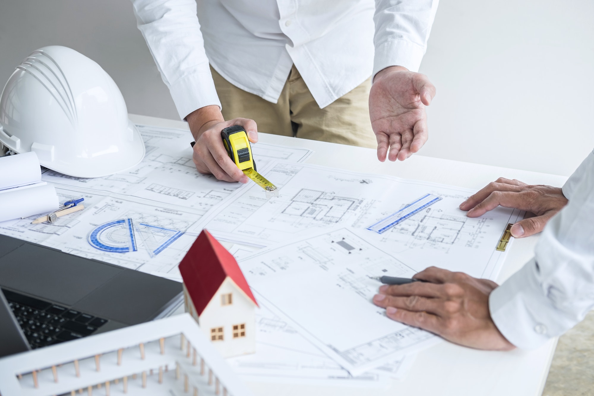 Construction engineering or architect discuss a blueprint while checking information on drawing and